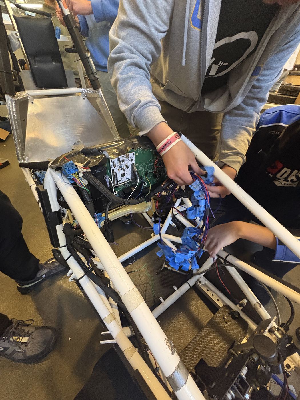 Wiring the low-voltage harness into the chassis, with the main board mounted behind the firewall.